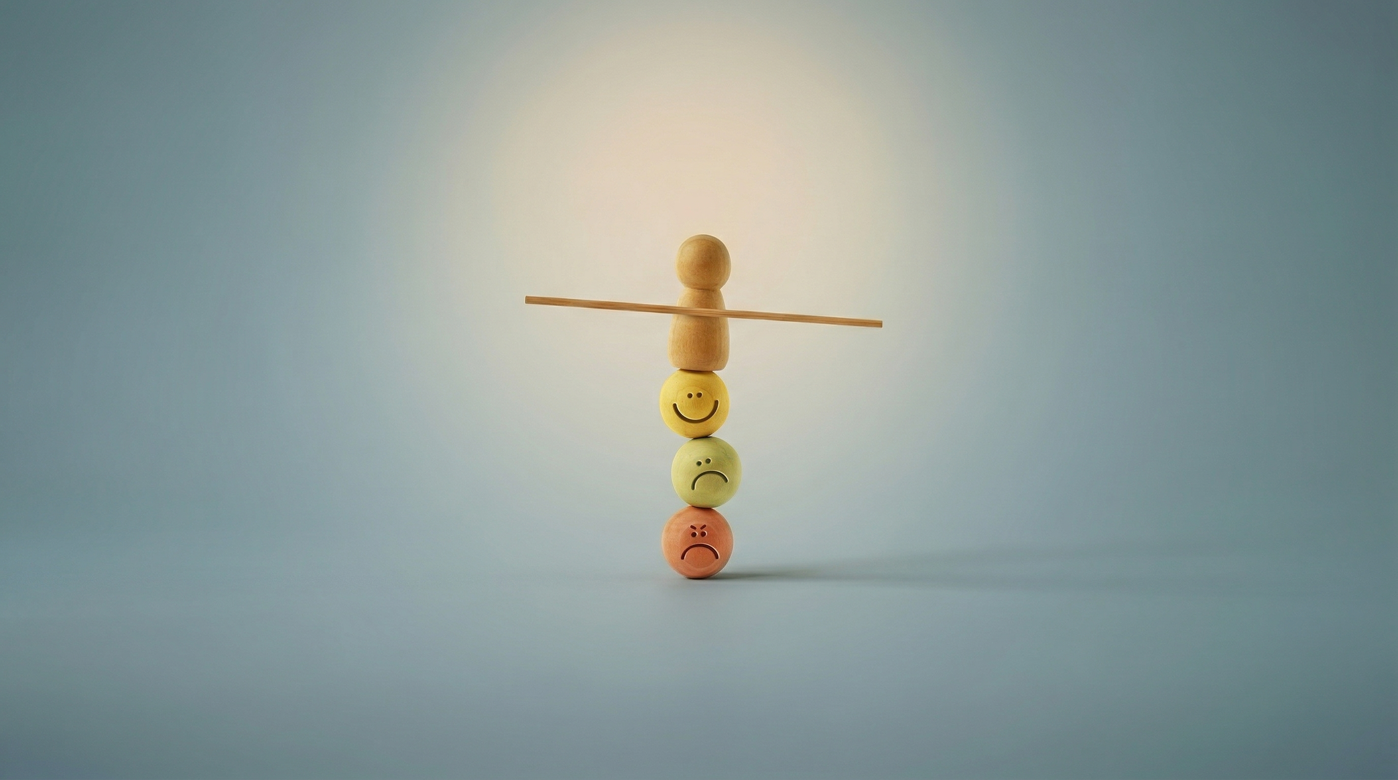 Ξύλινη φιγούρα σε ισορροπία πάνω σε σφαίρες με εκφράσεις συναισθημάτων